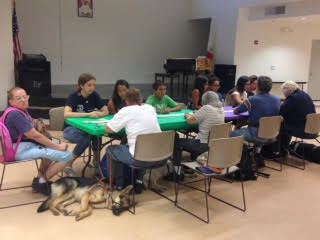 Group of young people engaged in an activity around a table indoors.