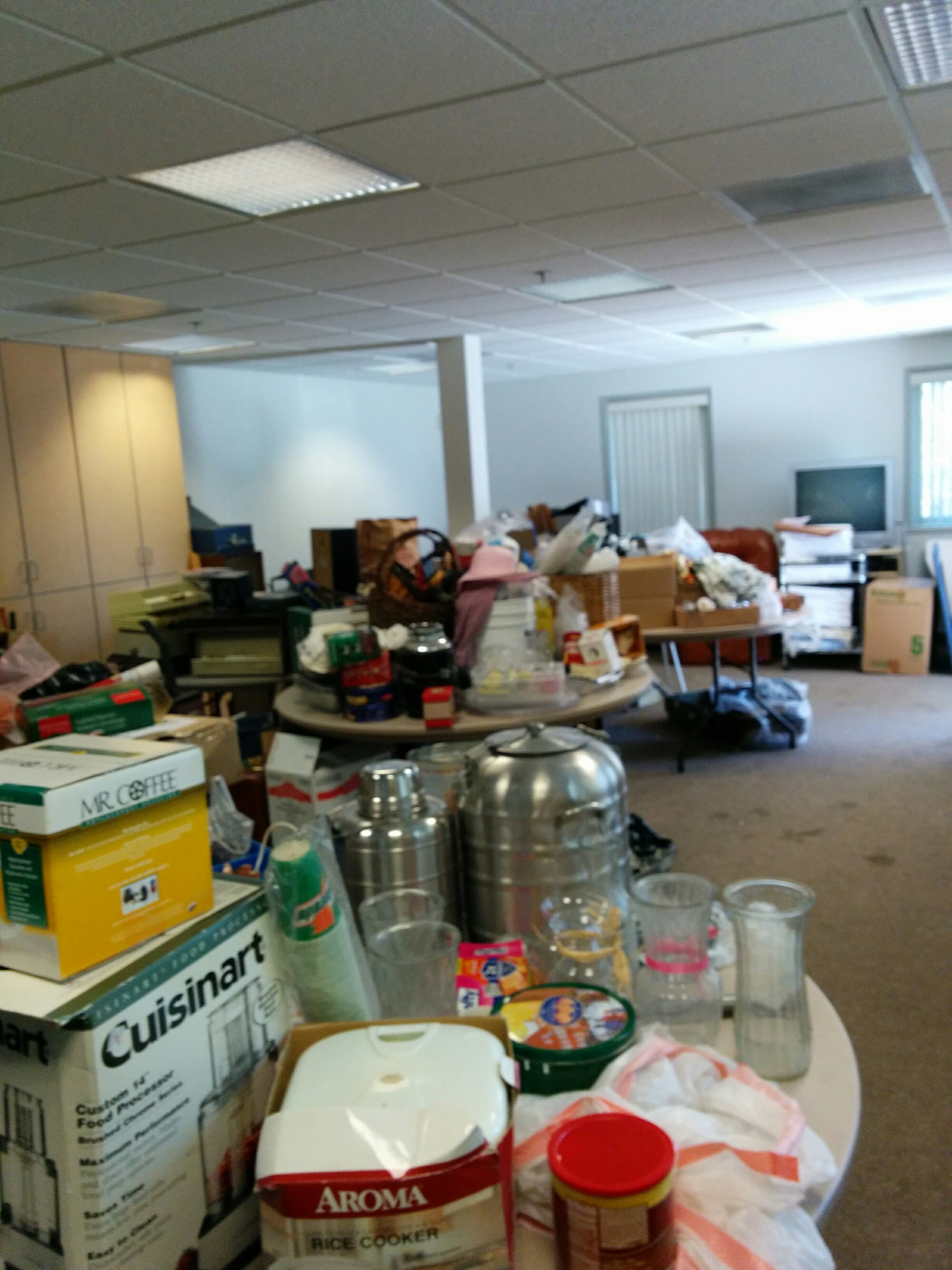 Cluttered office space with boxes and various items scattered around.