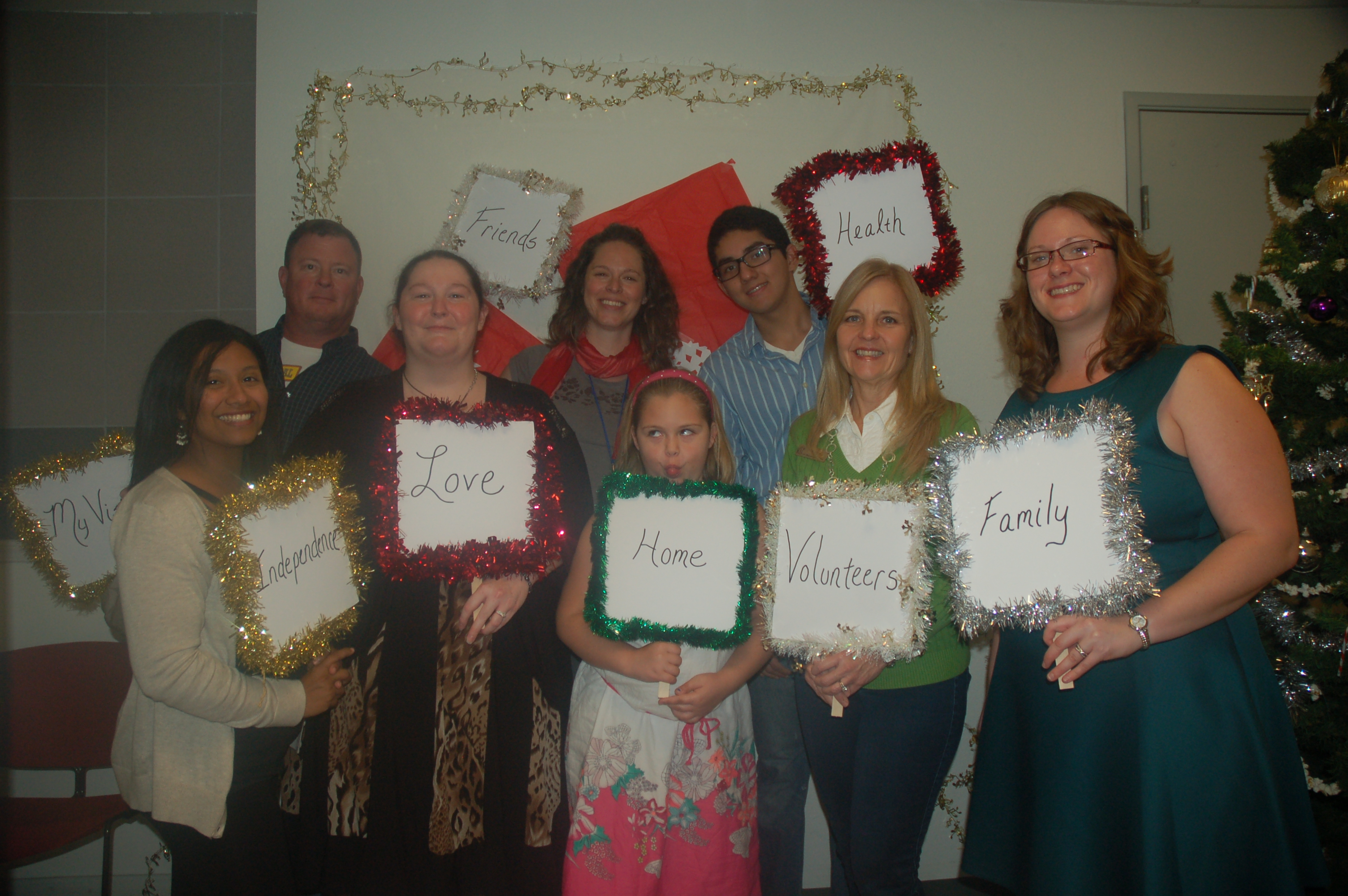 Group of people holding framed words about love and family.