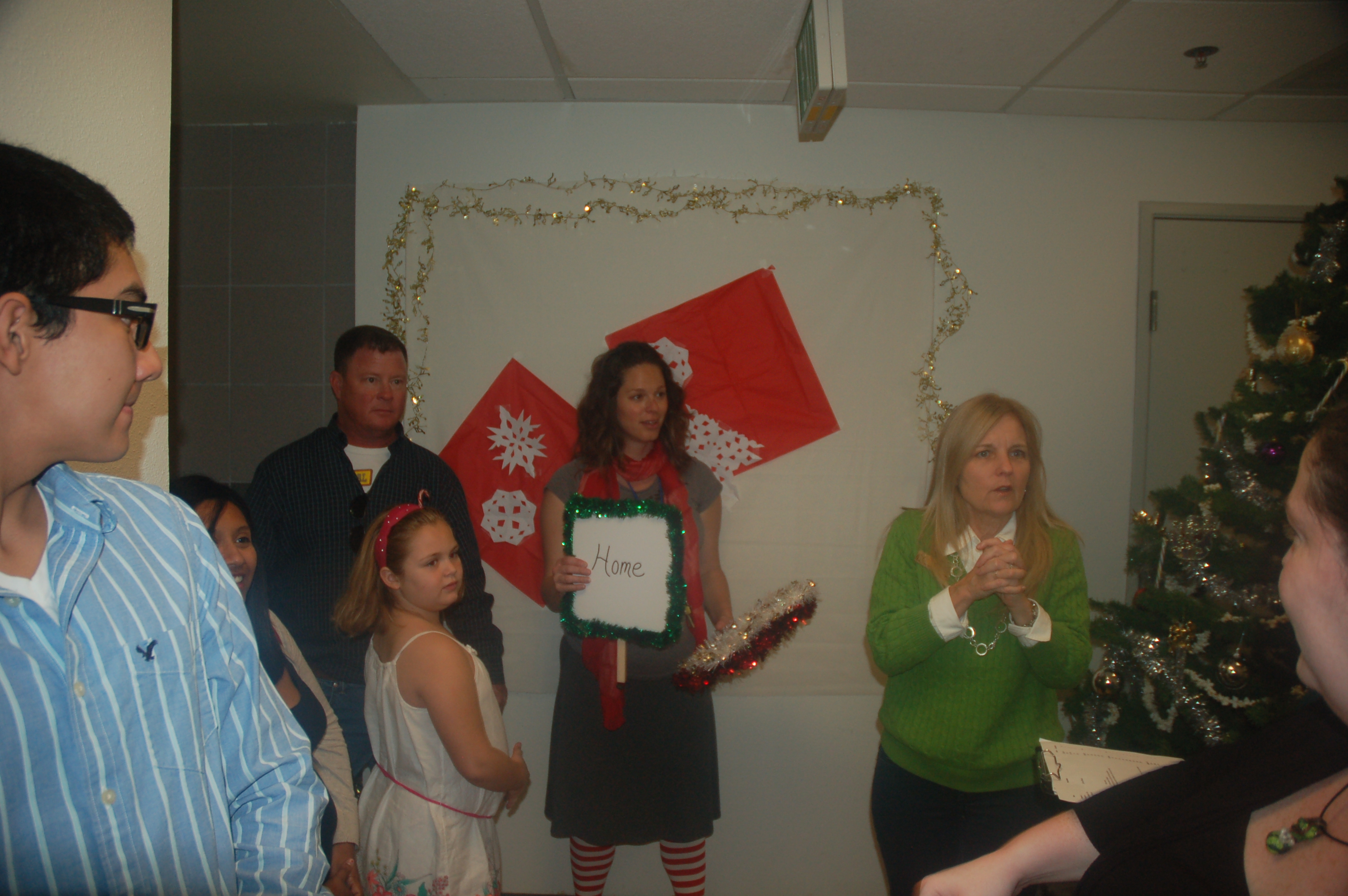 Group of people posing at a holiday-themed event with decorations.