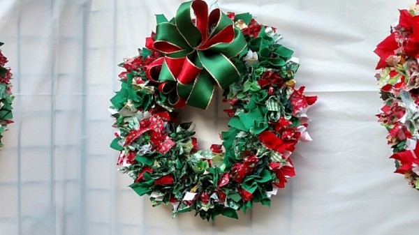 Festive Christmas wreath with red and green decorations and a big bow.