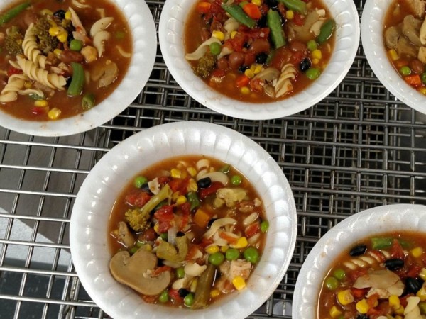 Bowls of colorful vegetable soup on a wire rack.