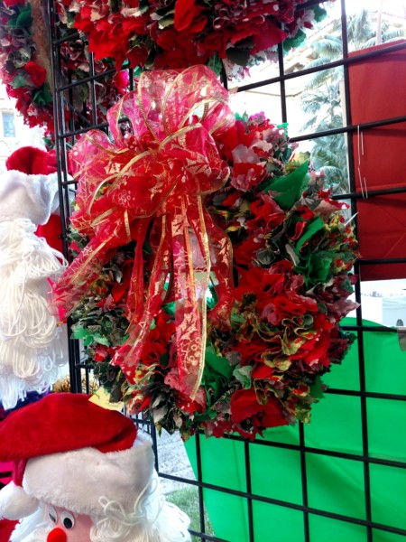 Festive Christmas wreath decorated with red bows and greenery.