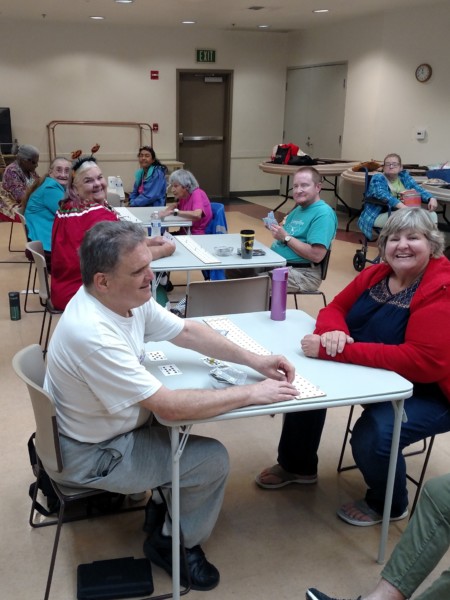 Seniors playing cards and socializing in a community room.