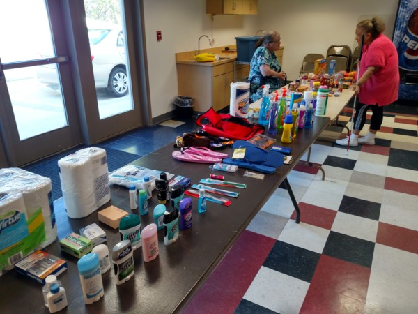 Table displaying various colorful school supplies and personal care items in a room.