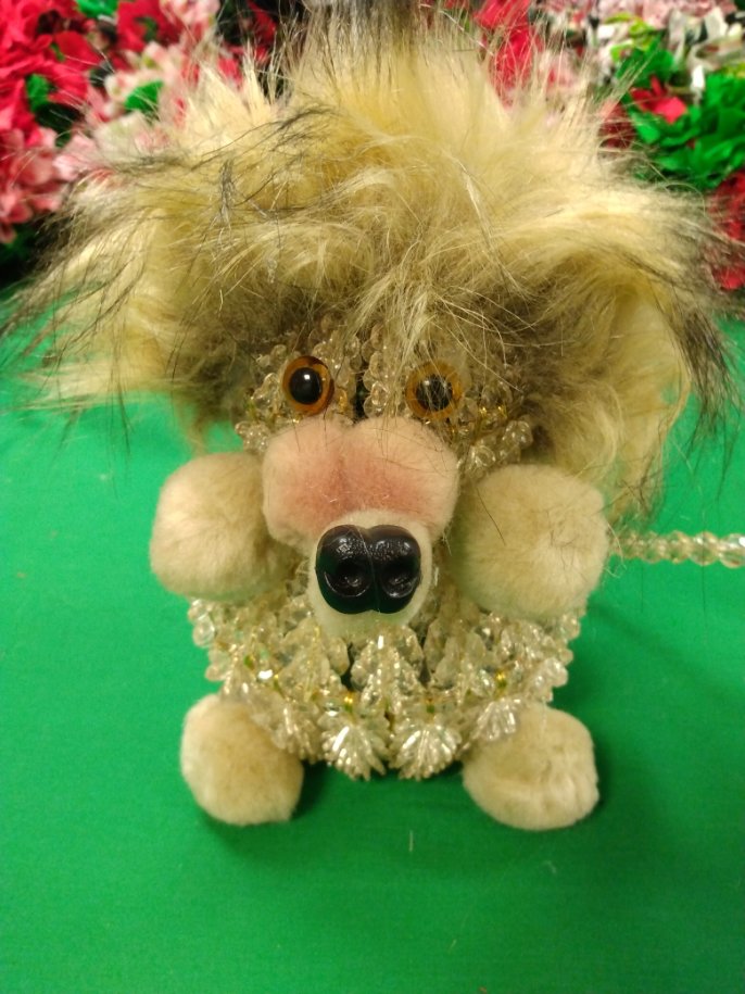 A cute plush lion with fluffy mane and big nose on green background.