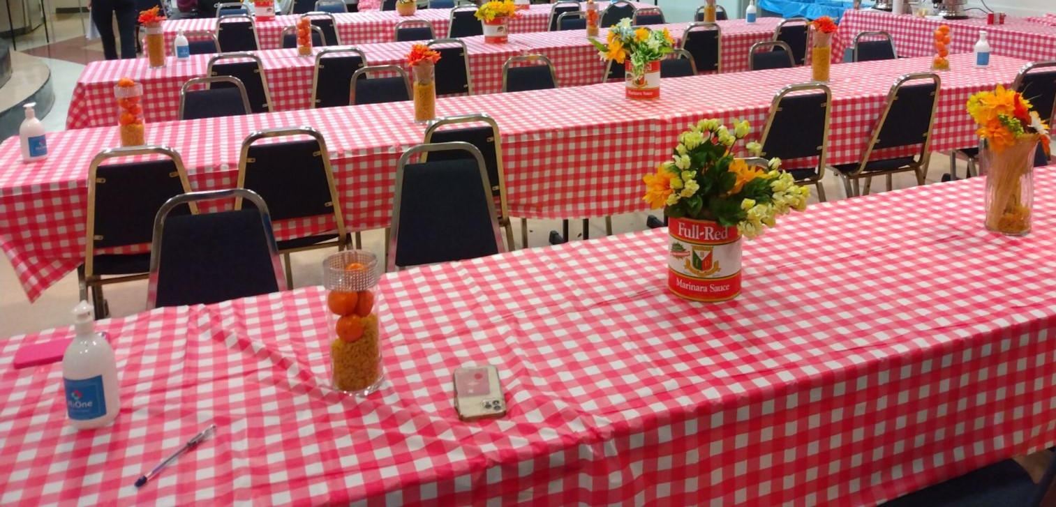 Tables with red and white checkered tablecloths and flower centerpieces.